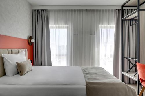 a bedroom with a large bed and a window at Hotel Milo Gdansk Airport in Gdańsk