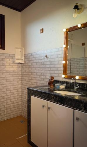 a bathroom with a sink and a mirror at Chácara Amsterdam in Aracaju