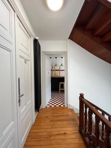 - un couloir doté de parquet et d'une porte dans l'établissement Chambre 01 indépendante centre Yssingeaux, à Yssingeaux