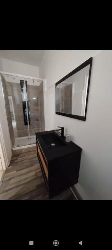 une salle de bain avec un lavabo noir et un miroir dans l'établissement Superbe Appart 4 chambres Terrasse vue sur les Montagnes, à Saint-Paul-de-Fenouillet
