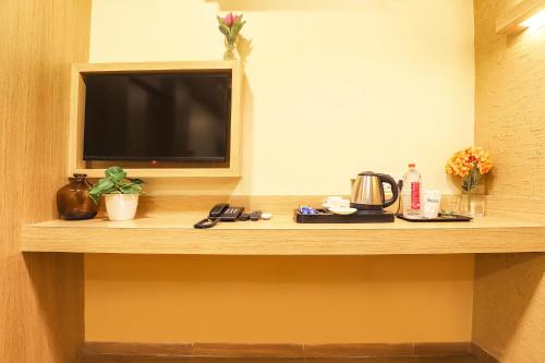 a flat screen tv sitting on a counter in a hotel room at FabHotel Nestlay Rooms High Court - Nr Parry's Corner in Chennai