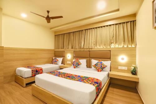 a bedroom with two beds and a ceiling fan at FabHotel Nestlay Rooms High Court - Nr Parry's Corner in Chennai