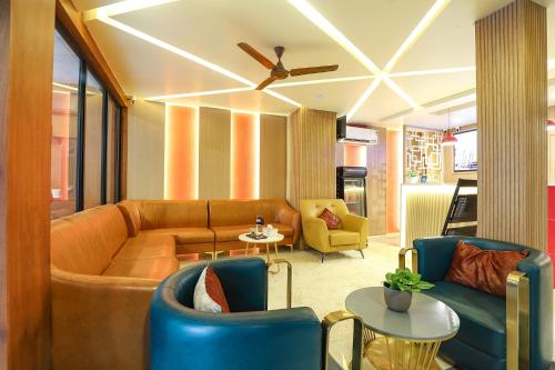 a living room with a couch and chairs at FabHotel Nestlay Rooms High Court - Nr Parry's Corner in Chennai
