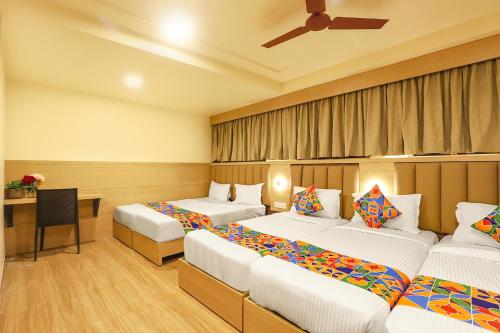 a hotel room with two beds and a table at FabHotel Nestlay Rooms High Court - Nr Parry's Corner in Chennai