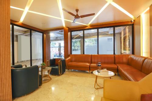 a living room with a couch and a ceiling fan at FabHotel Nestlay Rooms High Court - Nr Parry's Corner in Chennai
