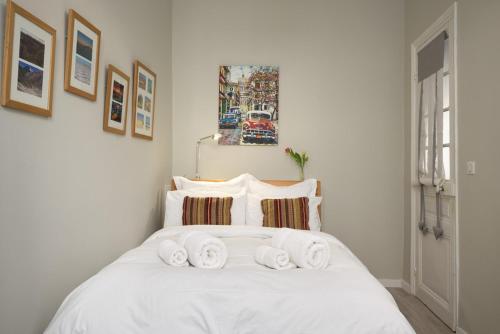 une chambre avec un lit blanc avec des serviettes dessus dans l'établissement Sunlight Properties - Gisele - Nice hyper central, 1 bedroom with large living room, à Nice