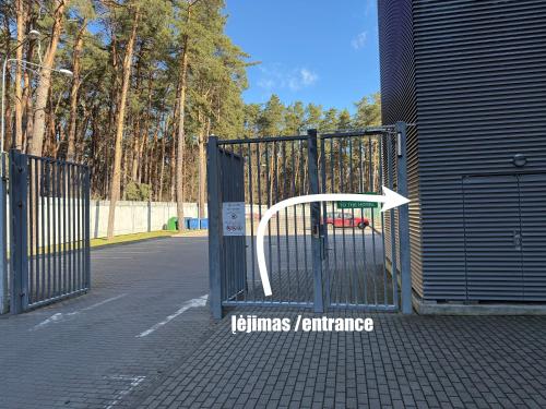 an open gate with an arrow pointing into a park at Alytaus sporto viešbutis Self Check-in in Alytus