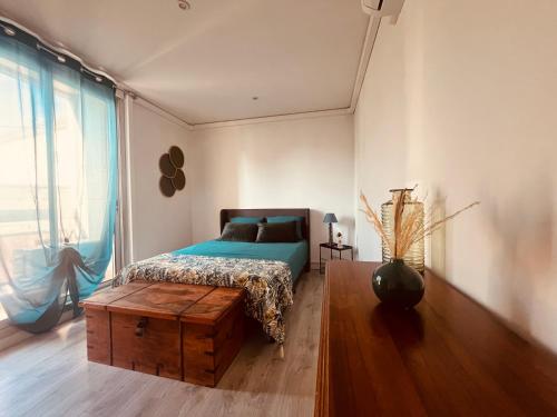 une chambre avec un lit avec une table en bois et une fenêtre dans l'établissement Le Félicité appartement spacieux avec parking, à Nîmes