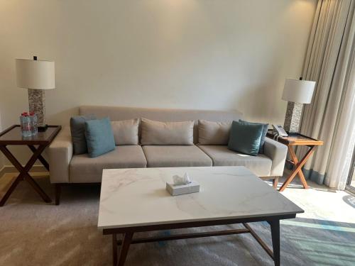 a living room with a couch and a coffee table at Address beach resort Fujairah Apartment in Fujairah