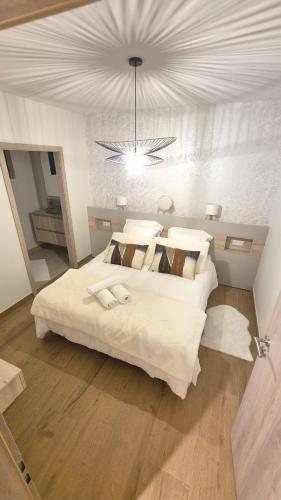 une chambre avec deux lits et un lustre dans l'établissement Magnifique maison bien-être 5 étoiles avec piscine et spa, à Kerprich-aux-Bois