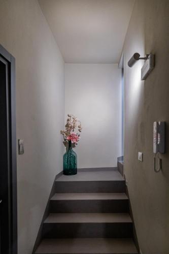 a vase with flowers sitting on top of a staircase at Dea's Rooms in Noto