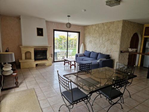 un salon avec un canapé bleu et une table dans l'établissement Maison dans le Périgord vert, à Saint-Martial-de-Valette