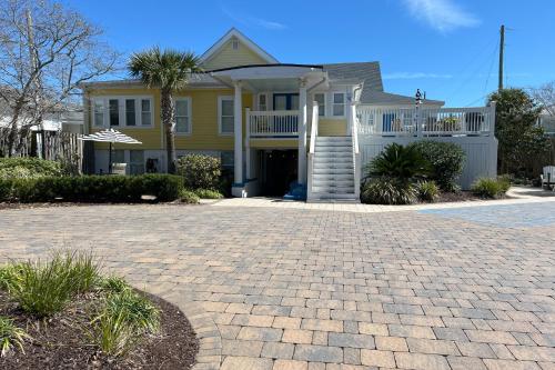 a yellow house with a porch and a driveway at Georgianne Suite Two in Tybee Island