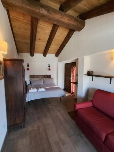 a bedroom with a bed and a red couch at Rifugio Alpino Baudinet - Trek&Relax in Chiusa di Pesio