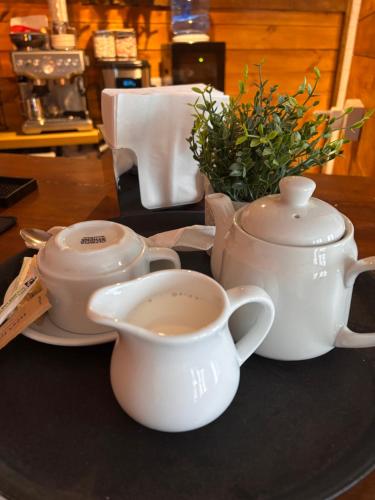 a table with two tea pots and a cup of coffee at SantalijsHoteliers Ltd in Leicester