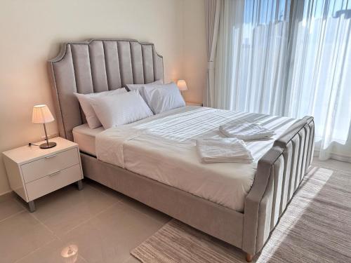 a bedroom with a large bed with a large window at 1BR Apartment with Private Jacuzzi in JVC - JLiving in Dubai