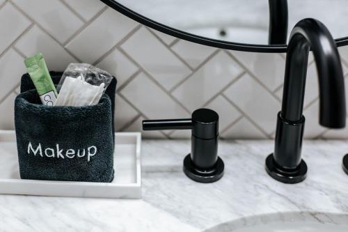 a black toothbrush holder sitting on a counter next to a sink at North Central Loft in Staunton