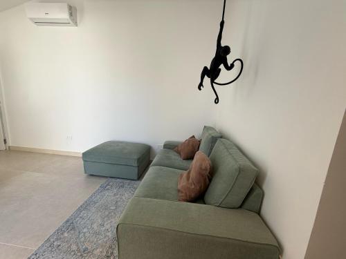 a living room with a green couch and a person on the wall at Buona Onda Apartments in Siracusa