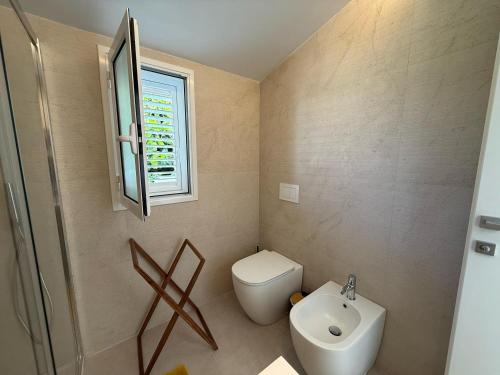 a small bathroom with a toilet and a sink at Buona Onda Apartments in Siracusa