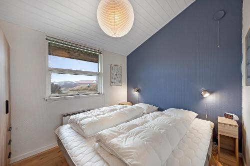 a white bed in a room with a window at Charming Holiday Home Close To The North Sea And Søndervig Center in Ringkøbing