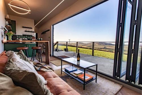 a living room with a couch and a large window at Contemporary Container with hot tub in Bath