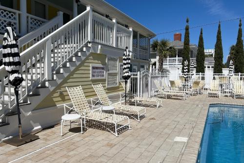 a group of chairs sitting next to a swimming pool at Georgianne Suite Five in Tybee Island
