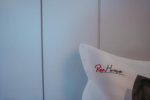 a white pillow with a red line on it at ResHome Apartments&Rooms in Focşani