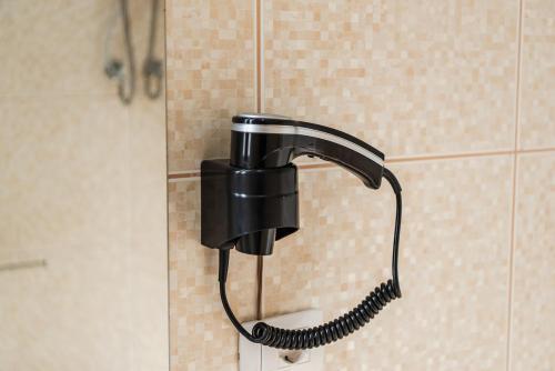 a black shower head hanging on a wall at Coastal Haven Talea in Tale