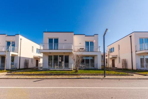 a row of white apartment buildings on a street at Coastal Haven Talea in Tale