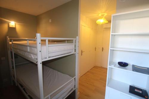 Cette petite chambre comprend des lits superposés et un placard. dans l'établissement Gasjoly - Golfe de St-Tropez Studio avec cabine climatisé pour 4 personnes, à Gassin