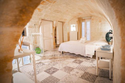 a bedroom with a bed and a table in a room at Le Volte Di San Leonardo in Monopoli