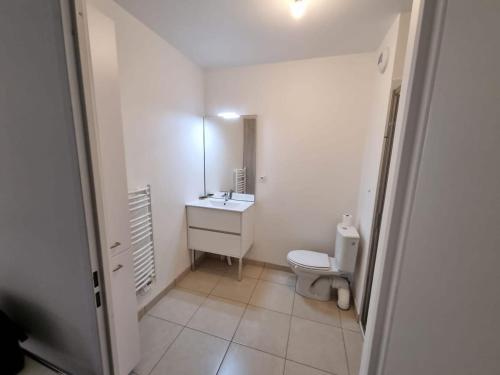 une salle de bain avec toilettes, lavabo et miroir dans l'établissement L ' Encre II, à Benerville-sur-Mer