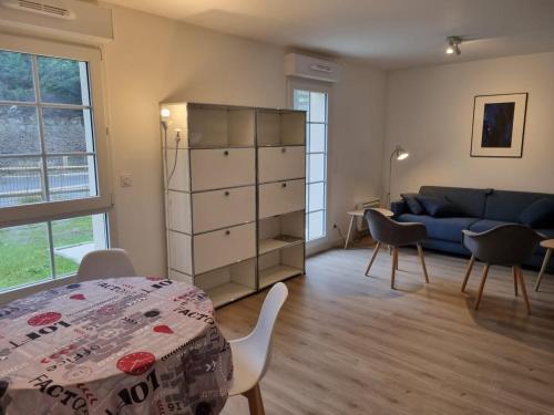 un salon avec une table et un canapé bleu dans l'établissement L ' Encre II, à Benerville-sur-Mer