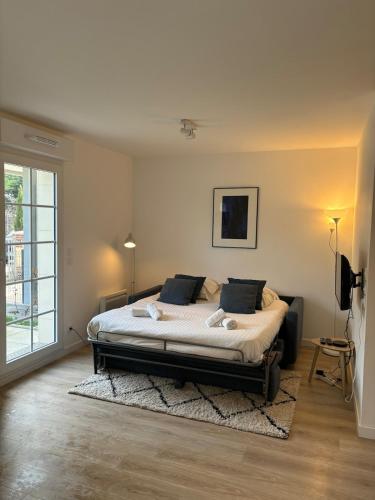 une chambre avec un grand lit dans une pièce dans l'établissement L ' Encre II, à Benerville-sur-Mer