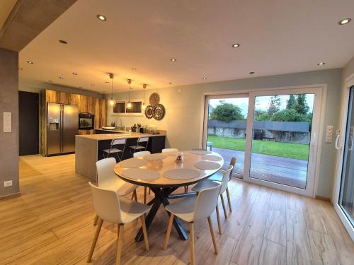 une salle à manger et une cuisine avec une table et des chaises dans l'établissement La Villa du Chêne, à Hombourg