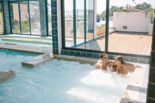 2 personnes sont assises dans une piscine dans l'établissement Camping Naturiste Riva Bella 4*, à Linguizzetta