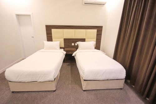 two beds in a small room withskirts at شقق المصيف للشقق المخدومة in Abha