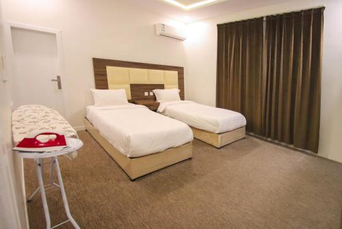 a hotel room with two beds and a table at شقق المصيف للشقق المخدومة in Abha