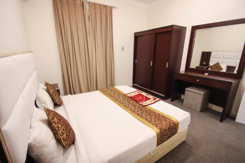 a hotel room with a bed and a mirror at شقق المصيف للشقق المخدومة in Abha