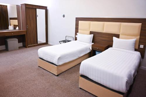 a hotel room with two beds and a mirror at شقق المصيف للشقق المخدومة in Abha
