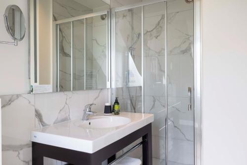 a bathroom with a sink and a shower at Hotel The Augustin in Brussels