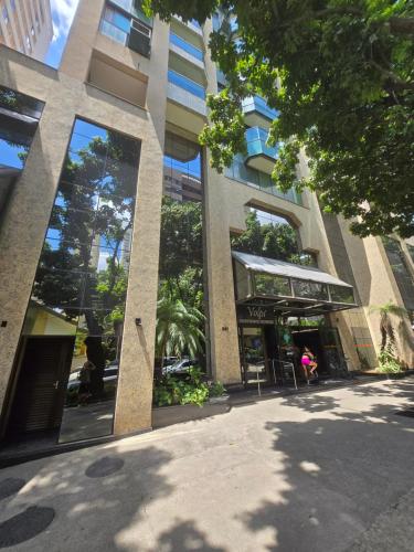 a large building with large windows on a city street at Apart Hotel Volpi 101 - Conforto & Comodidade in Belo Horizonte
