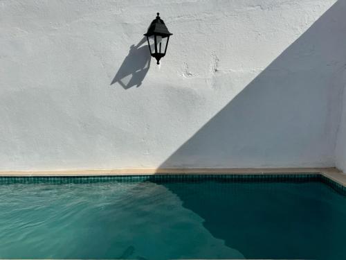 a light hanging from a wall next to a swimming pool at Casa Azul Barbacena in Barbacena