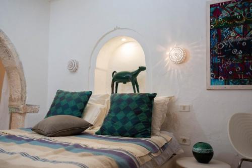 a room with a bed with a statue on top of it at La Maison Blanche -Les Houchs De Djerba in Erriadh