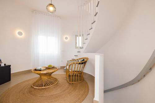 a room with a rattan chair and a table at Rocabella Santorini Hotel & Spa in Imerovigli