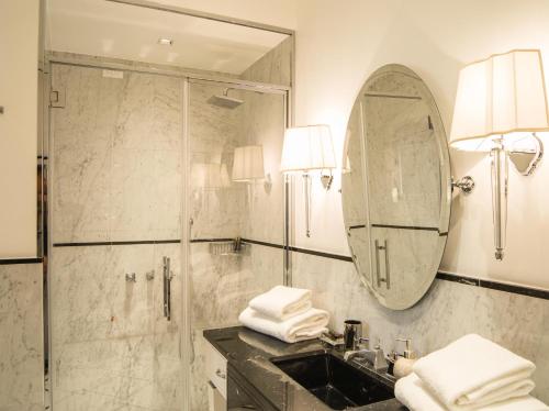 a bathroom with a shower and a sink and a mirror at Duomo Rooms in Milan
