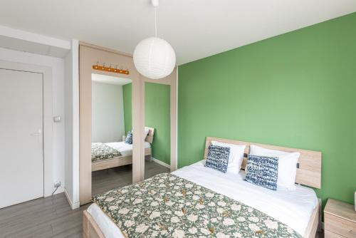 - une chambre avec un lit aux murs verts et un miroir dans l'établissement M30 Marquer Agréable T2 centre ville, à Annemasse