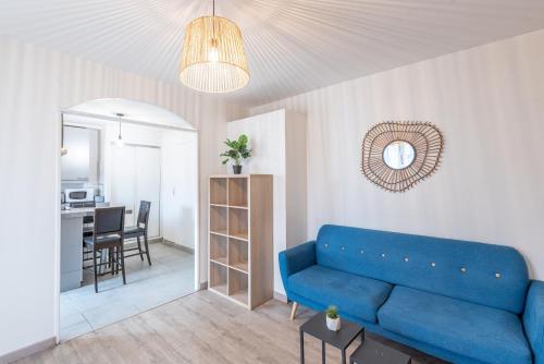 un salon avec un canapé bleu et une cuisine dans l'établissement M30 Marquer Agréable T2 centre ville, à Annemasse