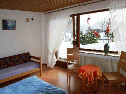 ein Wohnzimmer mit einem Bett und einem Fenster in der Unterkunft Haus Schwarzwald in Furtwangen