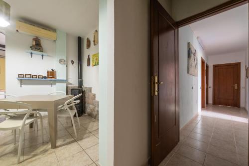 a kitchen and dining room with a table and a door at Gio's Gio's House in Monserrato